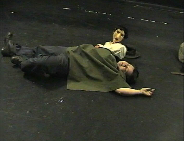 Agnes [played by an actor] lies asleep on the ground. Matilda [ a puppet] is watching her as she sleeps.